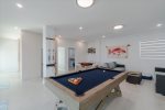 Indoor/outdoor entertainment room with TV, pool table and domino table.